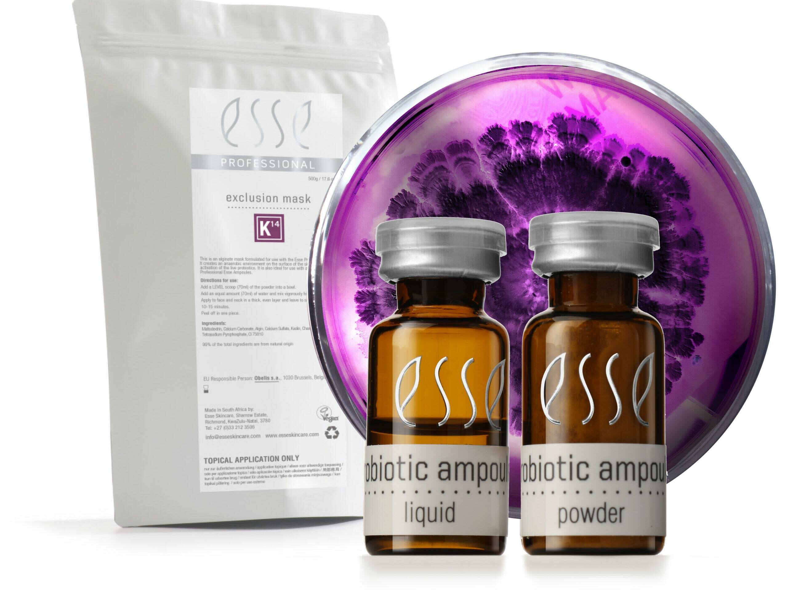 A product set featuring a white packet labeled "exclusion mask" beside two brown bottles labeled "probiotic ampoule" with "liquid" and "powder" respectively. Behind them is a petri dish with a purple culture. The brand name "Esse" is displayed on all items.