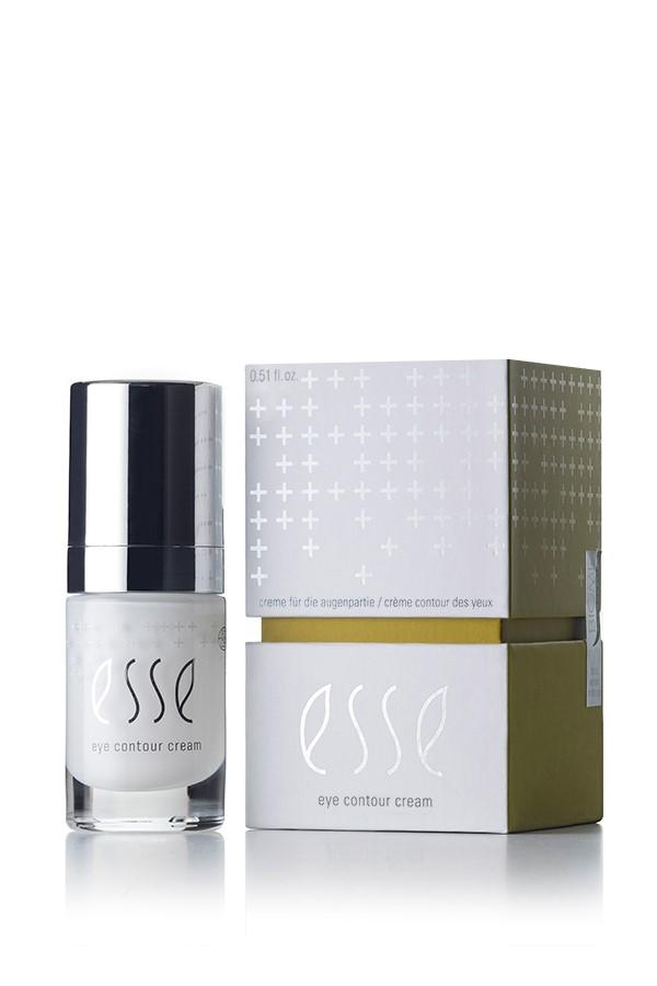 A small bottle of Esse Eye Contour Cream is positioned next to its packaging box. The sleek bottle features a silver cap and a white label with the brand name "Esse." The box is adorned with white plus signs on a grey and green background.